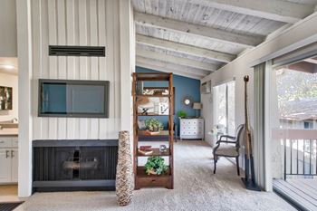 A living room with a fireplace and a chair at Mediterranean Village Costa Mesa, Costa Mesa, CA